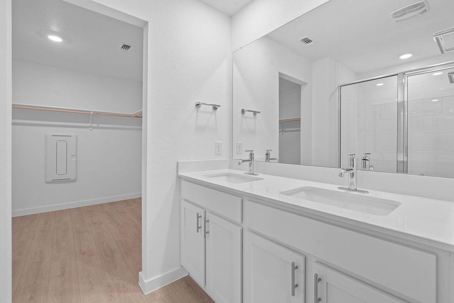 Full bathroom featuring a spacious closet, recessed lighting, double vanity, light wood-style flooring, and a shower stall