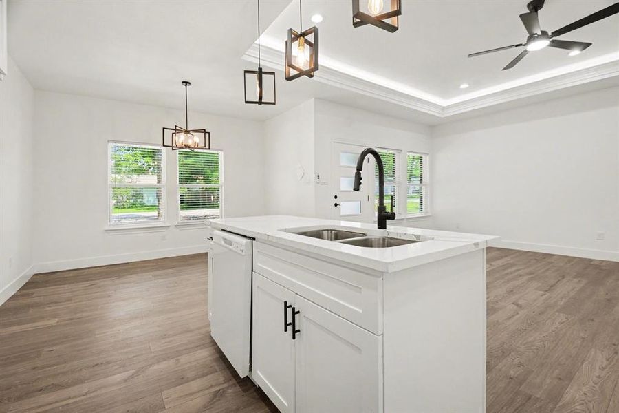 Open concept living area with light wood-look flooring and white walls