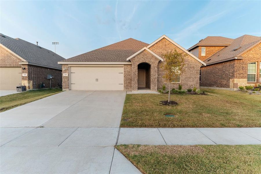 View of front of house with brick siding, a front lawn, concrete driveway, roof with shingles, and an attached garage View of front of house with brick siding, a front lawn, concrete driveway, roof with shingles, and an attached garage