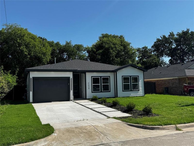 Single story home with an attached garage, driveway, and roof with shingles