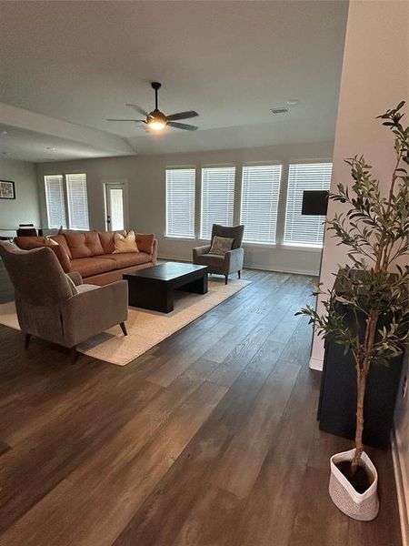 Living room featuring dark wood-style floors and a ceiling fan Living room featuring dark wood-style floors and a ceiling fan