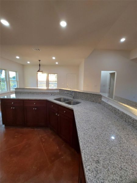 Kitchen with light stone counters and pendant lighting