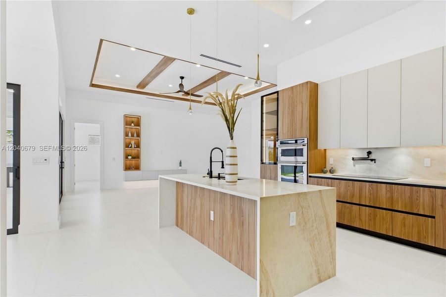 Custom cabinetry w/ under-cabinet & storage lighting, Taj Mahal-inspired quartz countertops & full backsplash