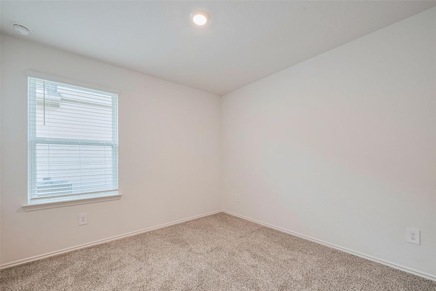 The third bedroom maintains the home’s light tones, with neutral carpeting and a large window that frames outdoor views while inviting sunlight in. The third bedroom maintains the home’s light tones, with neutral carpeting and a large window that frames outdoor views while inviting sunlight in.