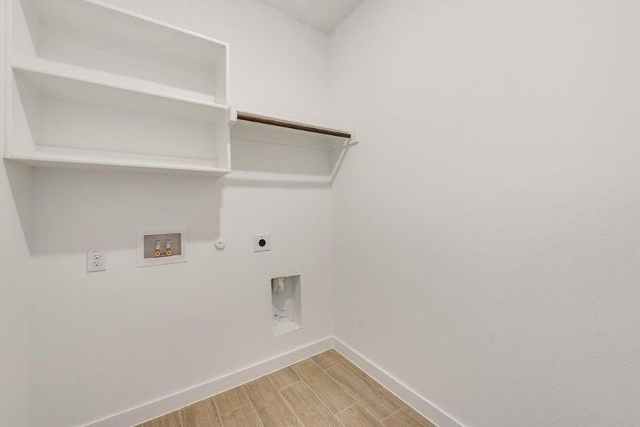 Laundry room featuring hookup for a gas dryer, electric dryer hookup, wood finish floors, and washer hookup