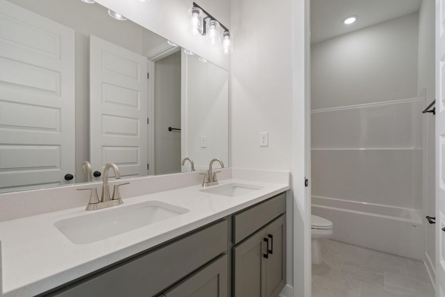 Double vanity featuring light-toned countertops and undermount sinks