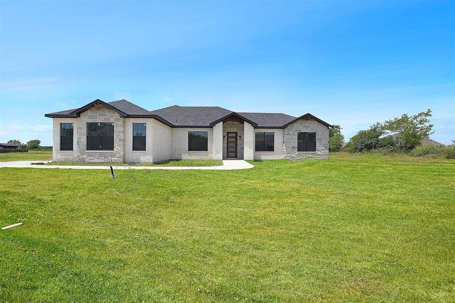 French country inspired facade featuring a front lawn