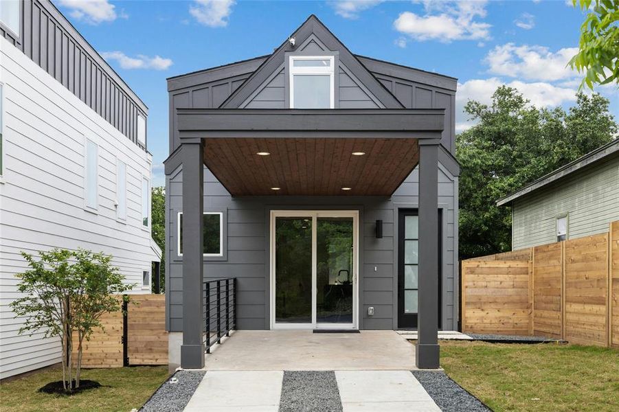 Doorway to property with board and batten siding and a patio area