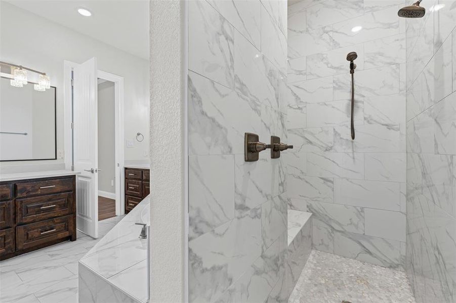 Primary Bathroom with vanity, a marble finish shower, and light marble finish flooring Primary Bathroom with vanity, a marble finish shower, and light marble finish flooring