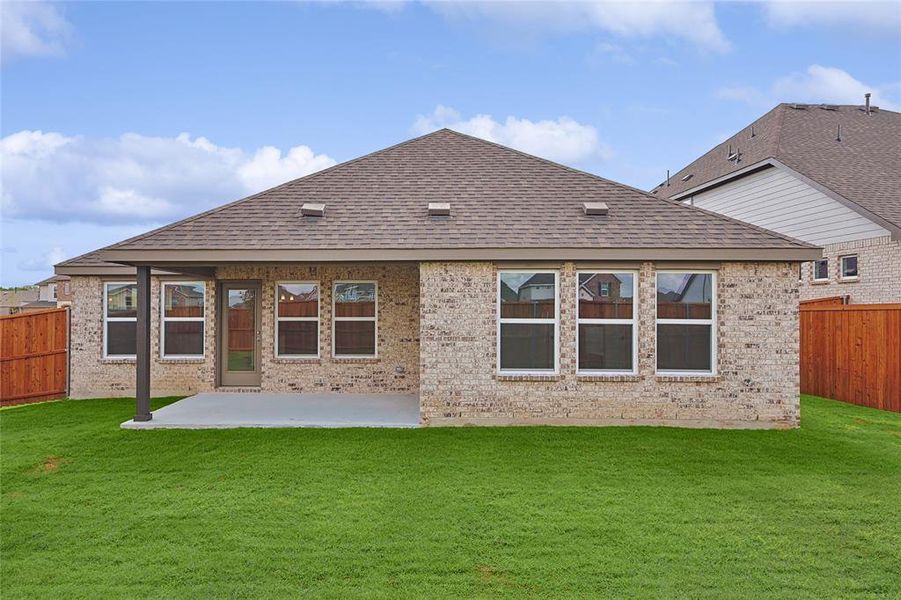 Rear view of house featuring a yard and a patio area