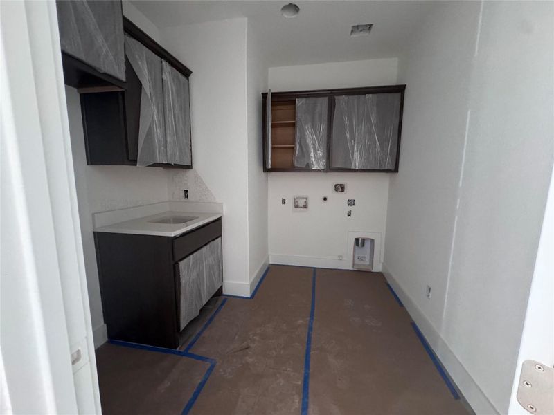 Functional laundry room offers a built-in sink for convenience. Functional laundry room offers a built-in sink for convenience.