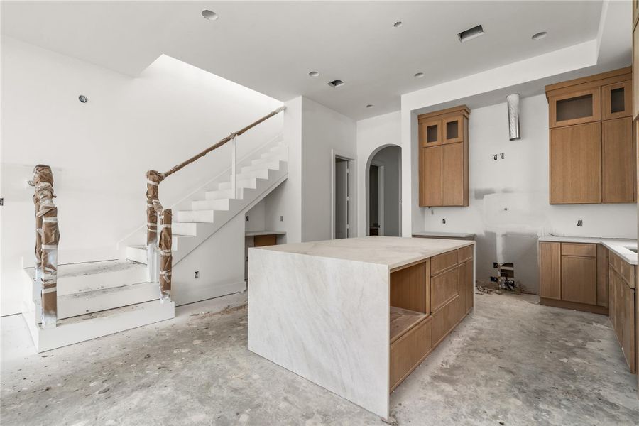 This home's kitchen comes with Taj Mahal counters, oversized island with storage on both sides, white oak slim shaker cabinetry, luxury Bosch appliances, Delta champagne bronze fixtures, and white oak wood flooring.