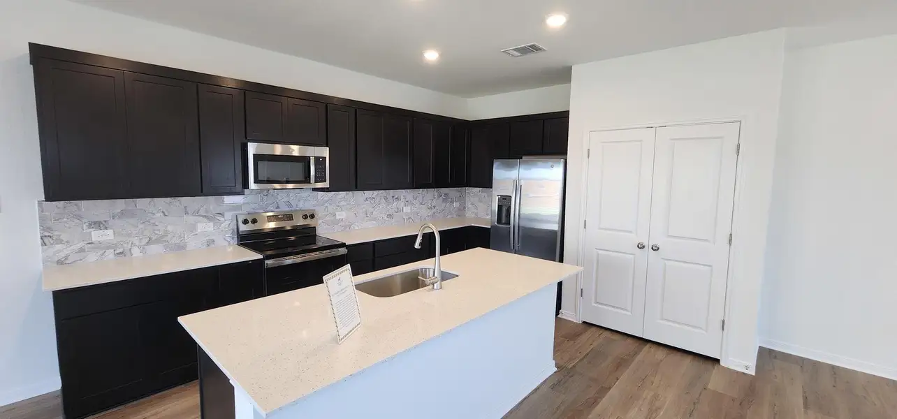 Culinary creations come to life in this modern kitchen featuring dark cabinetry and a central island. Culinary creations come to life in this modern kitchen featuring dark cabinetry and a central island.