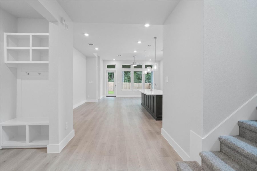 Once inside, the home unfolds into a magnificent open-concept layout, highlighting an integrated mudroom station, a striking island kitchen, and a soaring staircase. Once inside, the home unfolds into a magnificent open-concept layout, highlighting an integrated mudroom station, a striking island kitchen, and a soaring staircase.