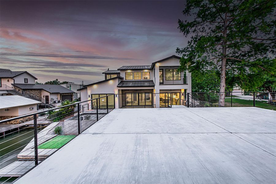 View of front of house with a standing seam roof, fence, stucco siding, and metal roof