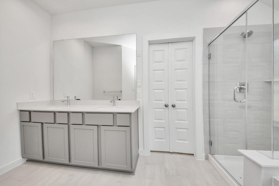 Elevate your daily routine at the elegant vanity, now equipped with double sinks, light countertops, modern hardware, and beautiful recessed lights.