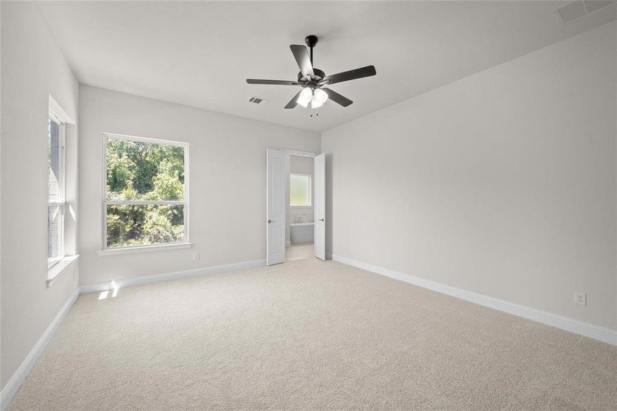 Carpeted spare room with ceiling fan