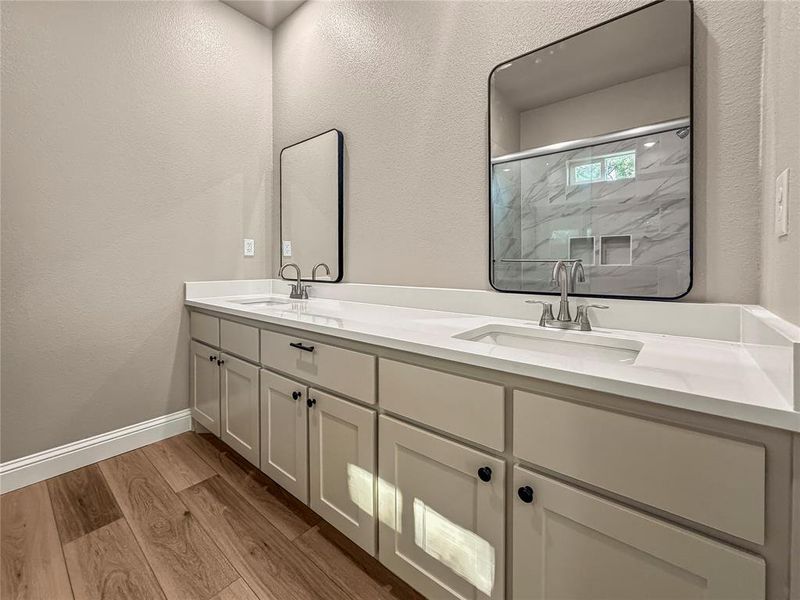 Dual vanity with white countertops, undermount sinks, and brushed nickel fixtures Dual vanity with white countertops, undermount sinks, and brushed nickel fixtures