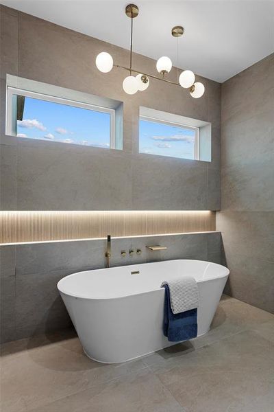 Bathroom with a wealth of natural light, tile walls, and tile patterned flooring