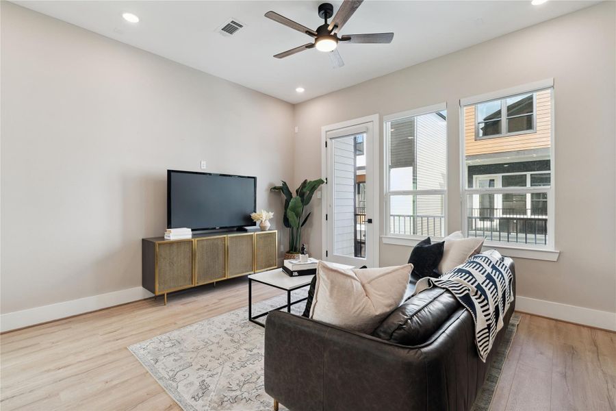 A linear focal point in the open plan, the living room radiates calm with balanced window spacing and layered textures.