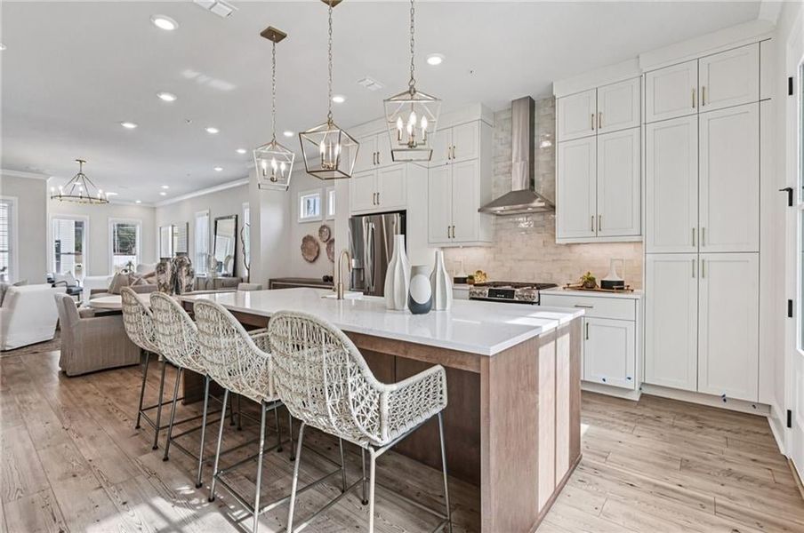 Another view of the stunning kitchen:  Carrera White stacked cabinets for plenty of storage with Modern gold finishes and farmhouse sink. Calacatta Miraggio Gold Quartz and Natural rice color 3 x 8 tile backsplash stacked.