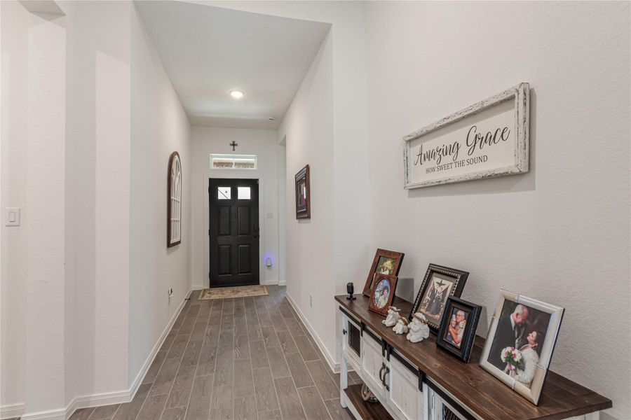 View of hallway leaving the office/study to front door. To the left is the laundry room and door leading to garage.