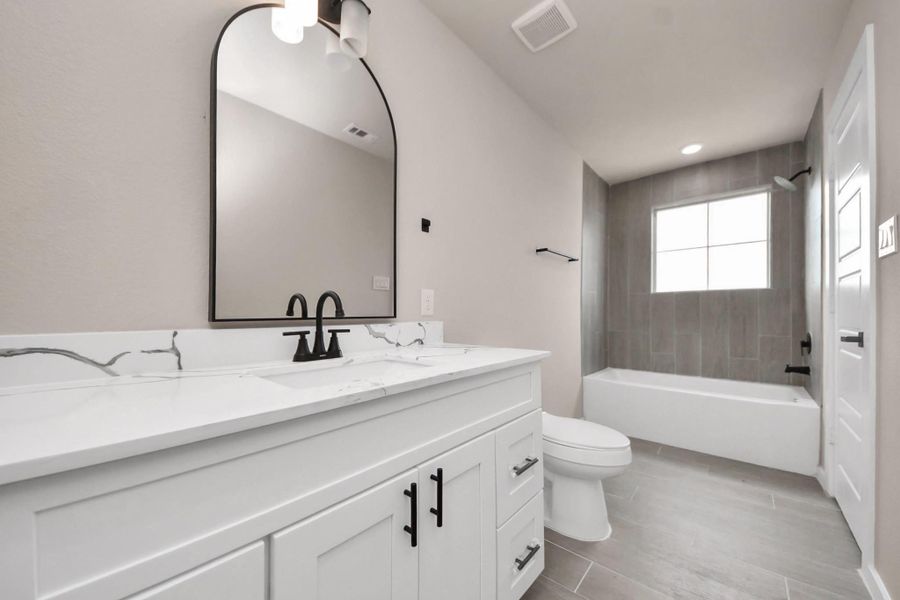 This bathroom features a modern design with a sleek vanity, marble countertop, and stylish black fixtures. It includes a bathtub with a tiled shower area and a large window for natural light. This bathroom features a modern design with a sleek vanity, marble countertop, and stylish black fixtures. It includes a bathtub with a tiled shower area and a large window for natural light.