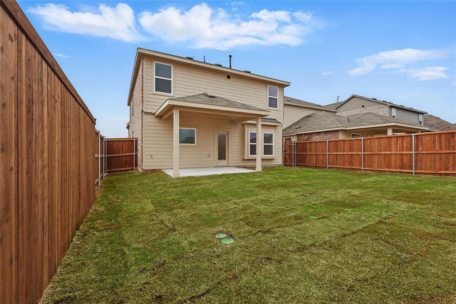 Rear view of house featuring a patio and a fenced backyard
