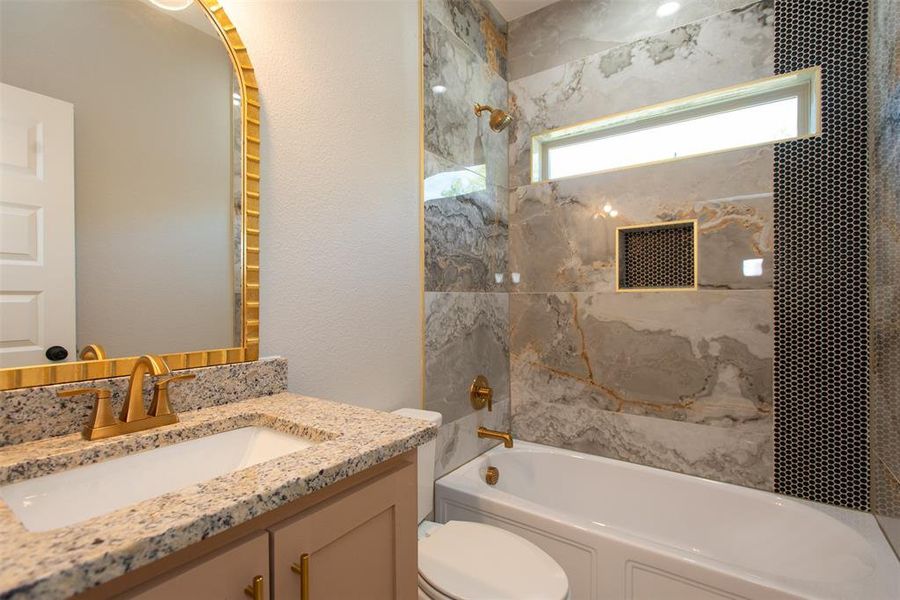 Full bathroom with vanity, toilet, and tiled shower / bath