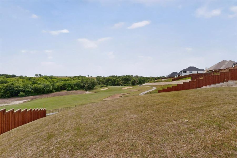 Golf Course facing lawn area with a stepped wood privacy fence Golf Course facing lawn area with a stepped wood privacy fence