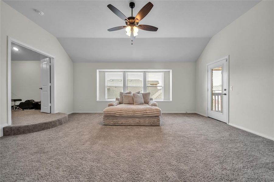 Sitting room with carpet flooring, lofted ceiling, and a ceiling fan Sitting room with carpet flooring, lofted ceiling, and a ceiling fan