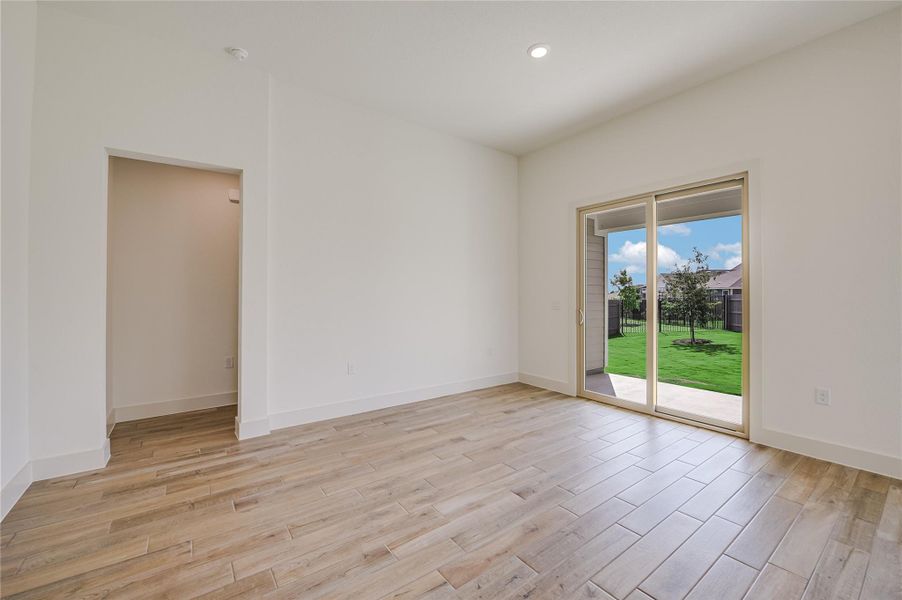 Empty room featuring light wood finished floors and recessed lighting