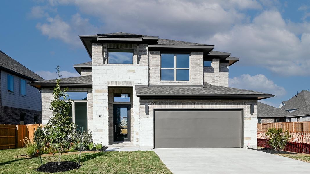View of front of property featuring roof with shingles, stone siding, an attached garage, concrete driveway, and brick siding View of front of property featuring roof with shingles, stone siding, an attached garage, concrete driveway, and brick siding