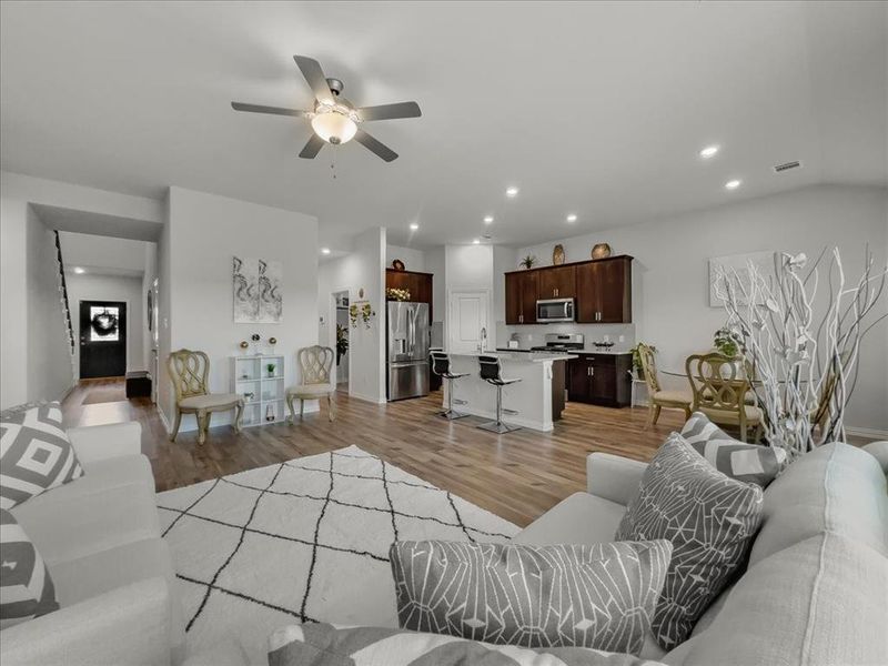 Living room featuring sink, ceiling fan, and light wood-type flooring