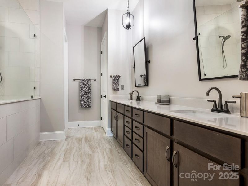 1st Flr, Primary Bath; dual vanities, large walk-in shower, linen closet and two separate custom closets