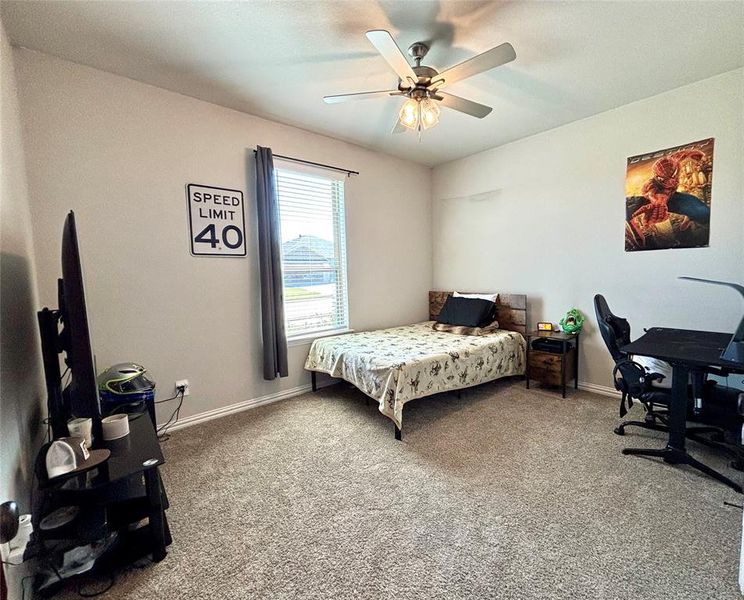 Bedroom featuring light colored carpet, a ceiling fan, and a desk Bedroom featuring light colored carpet, a ceiling fan, and a desk