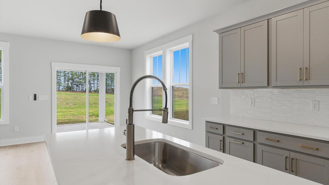 Highly skilled craftsmanship shines in this modern kitchen with pendant lighting and a central island focal point