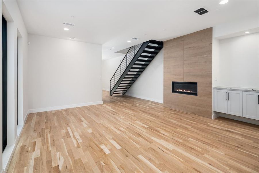 Unfurnished living room with a fireplace and light wood-type flooring