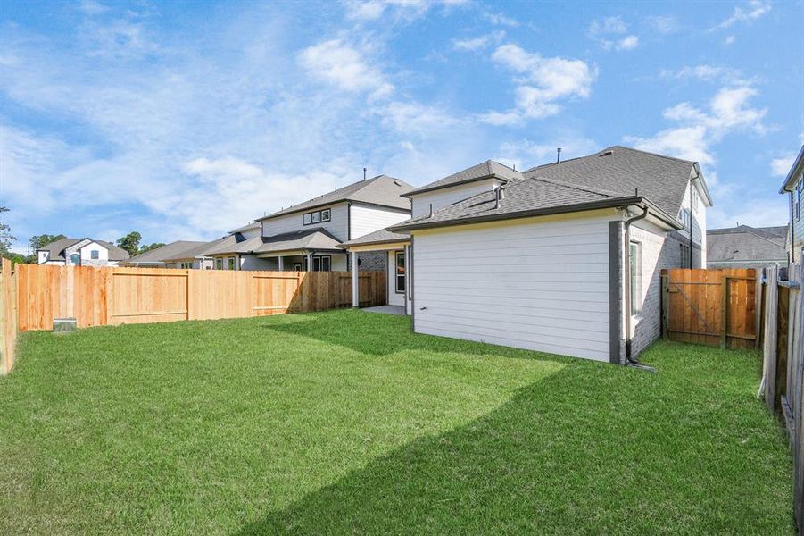 Discover the charm of this spacious backyard featuring a delightful covered patio. With ample room for both play and relaxation, it's the perfect outdoor haven. Tailor this space to your liking with patio furniture, a BBQ pit, and more. The potential for creating your dream outdoor living area is limitless!