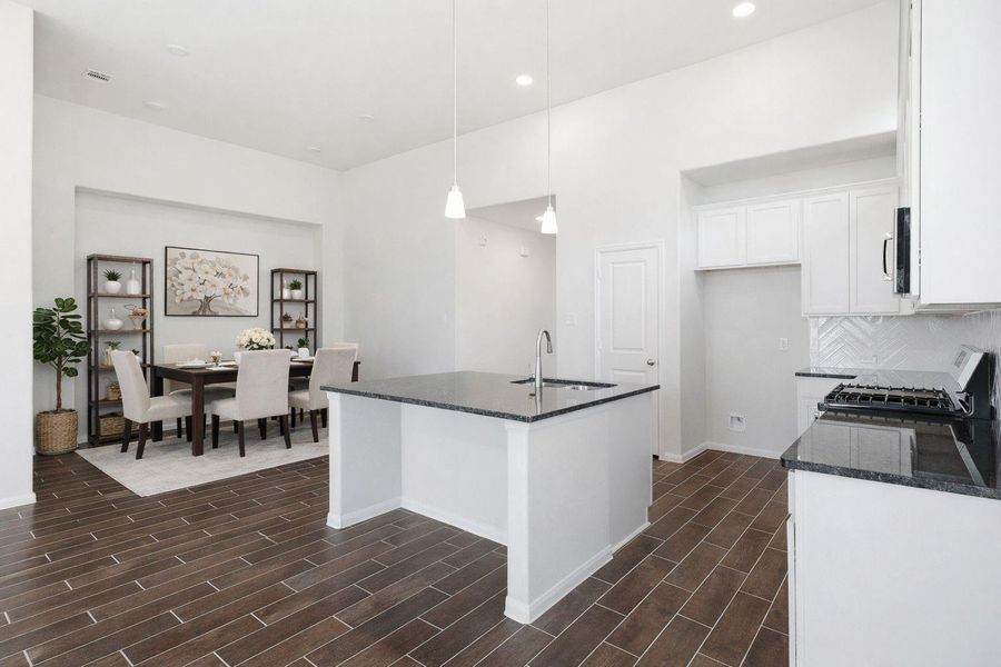 Another angle of the kitchen highlights the functional layout, ample cabinet storage, and expansive counter space, all complemented by durable wood look tile flooring throughout the main living areas. **Virtually Staged** Another angle of the kitchen highlights the functional layout, ample cabinet storage, and expansive counter space, all complemented by durable wood look tile flooring throughout the main living areas. **Virtually Staged**