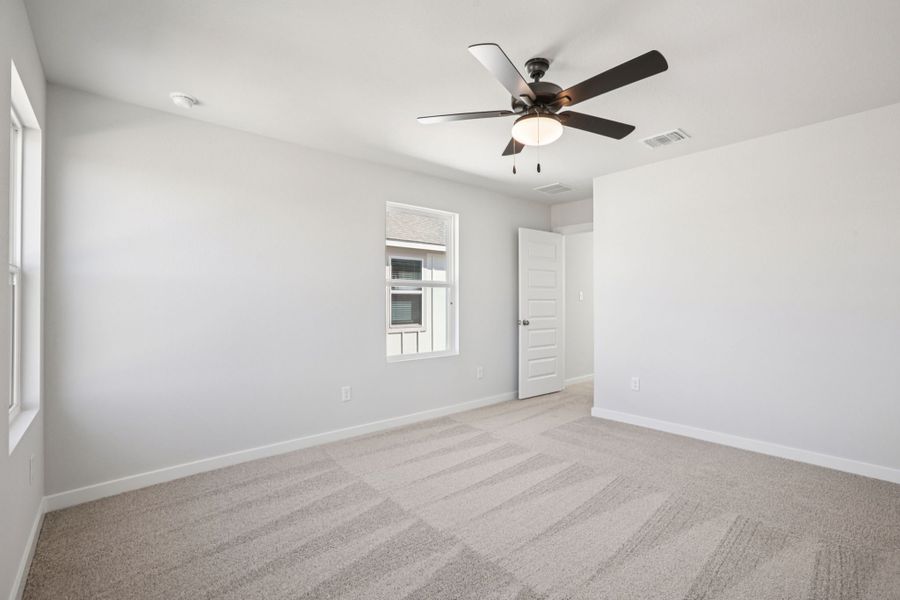 A room with a ceiling fan and a door.