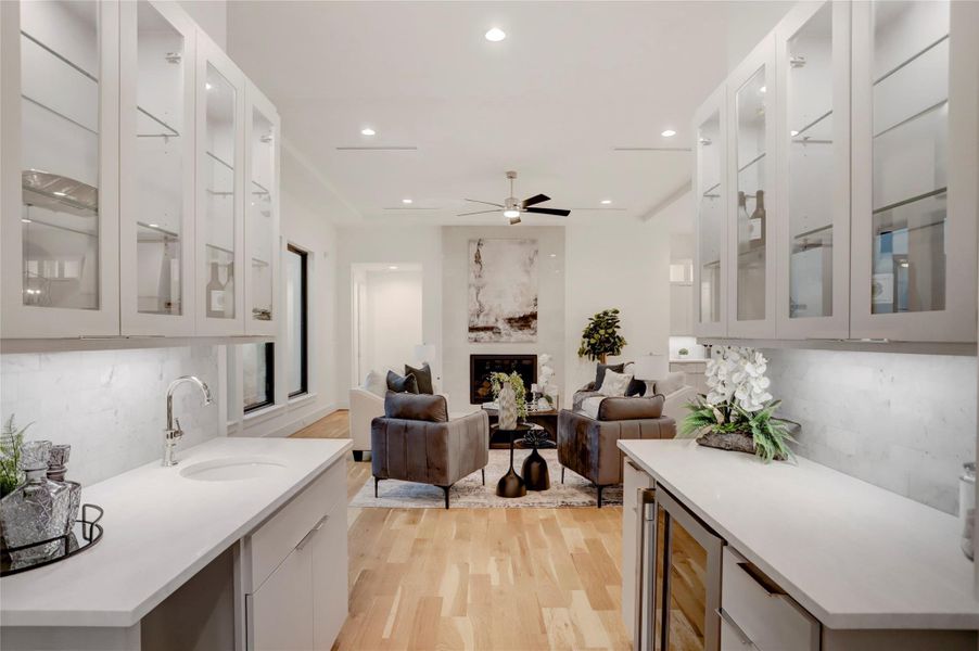 Sitting between the living and dining rooms is the wet bar/butler's pantry with a beverage fridge, space/plumbing for an ice maker, and glass-front cabinets.