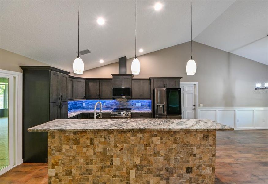 Travertine. Stone counters. Tile back splash. Under cabinet lighting. Custom cabinets.
