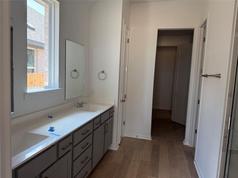 Bathroom featuring light wood-style floors and double vanity Bathroom featuring light wood-style floors and double vanity