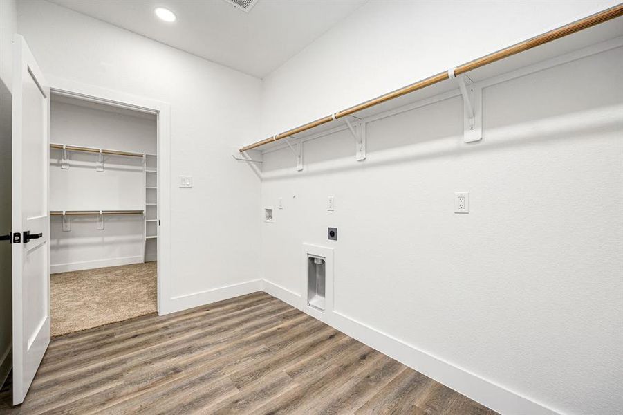 Spacious Laundry Room with Direct Access to Primary BedroomThis well-designed laundry room offers built-in shelving, hanging rods, and washer/dryer connections for ultimate convenience. Featuring stylish flooring and a functional layout, it provides direct access to the primary bedroom and walk-in closet, making laundry days effortless!