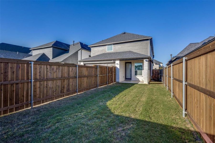 Back of house with a fenced backyard, a patio, and a shingled roof Back of house with a fenced backyard, a patio, and a shingled roof