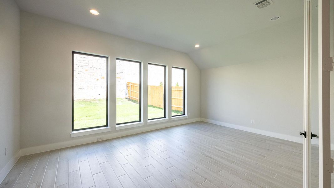 Spare room with recessed lighting, light wood-style floors, and vaulted ceiling Spare room with recessed lighting, light wood-style floors, and vaulted ceiling