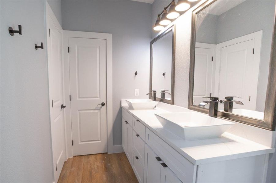 Bathroom featuring double vanity and wood finished floors