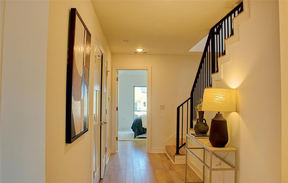 Corridor featuring light wood-style flooring and stairs