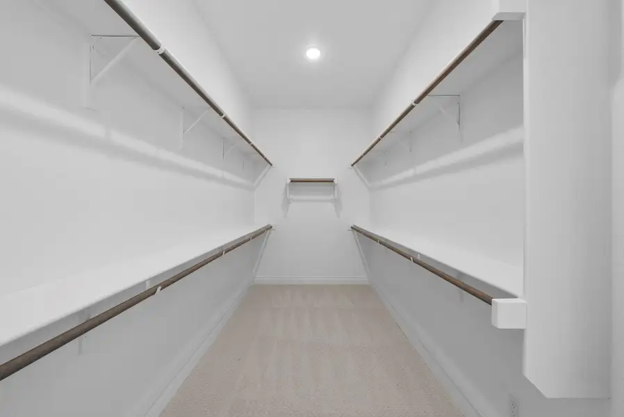 Generous walk-in closet with extensive hanging space and built-in shelving for optimal organization.